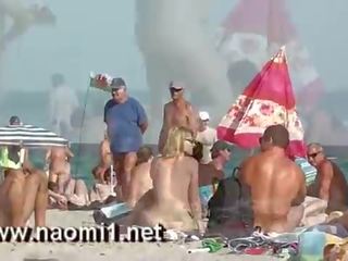 Naomi1 afrukken een jong jongeling op een publiek strand